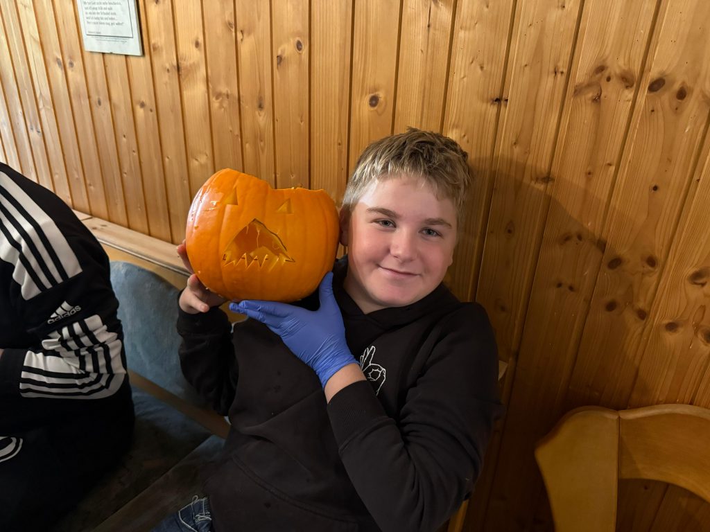 Stolze Kinder präsentieren ihren geschnitzten Kürbis bei der Vogelschutzhütte