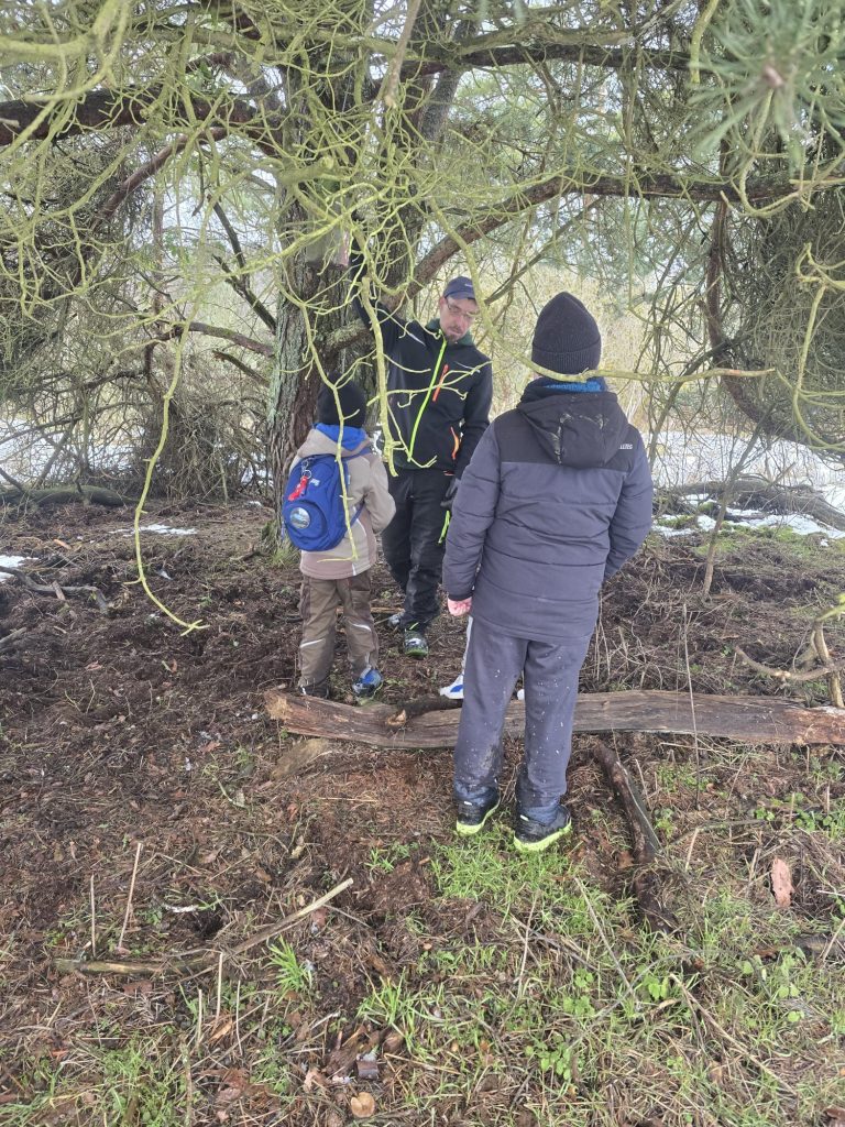 Betreuer erklärt Nistkästen Reinigung bei Winterwetter